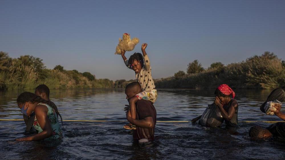 Migrants wade across Rio Grande river